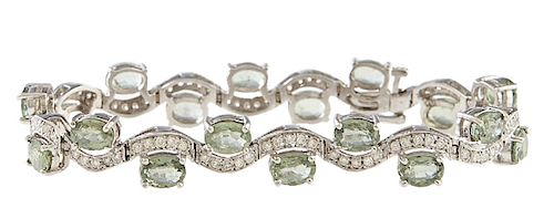 18K White Gold Link Bracelet, the eighteen curved links mounted with five round diamonds, each with a natural green app. one carat oval sapphire atop 