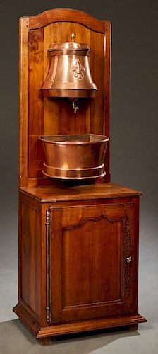 Fountain, Copper and Brass Lavabo, 19th c., the reservoir with a repousse fleur-de-lis, over a basin, on an arched carved walnut stand with a cupboard