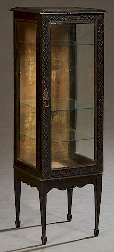 Diminutive English Ebonized Display Cabinet, early 20th c., the relief fretwork stepped edge top over a glazed door with like fretwork decoration, and