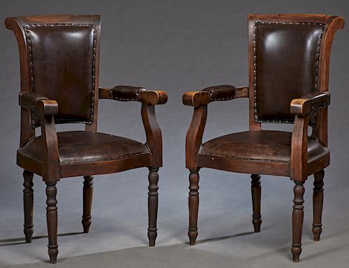 Pair of French Carved Walnut and Leather Fauteuils, c. 1900, the scrolled upholstered back to scrolled upholstered arms and bowed seats, on turned tap