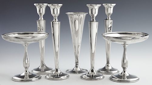 Seven Pieces of Sterling, 20th c., consisting of four weighted candlesticks, by Revere; a pair of weighted footed compotes, by Wallace; and a bud vase