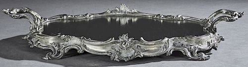 French Silverplate on Copper Mirror Plateau, 19th c., the shaped top with a relief scroll decorated frame and two side handles, on four pierced scroll