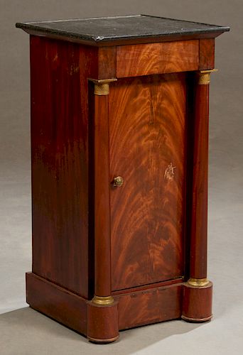 French Empire Style Ormolu Mounted Carved Mahogany Marble Top Nightstand, c. 1820, the dished black marble over a frieze drawer above a setback cupboa
