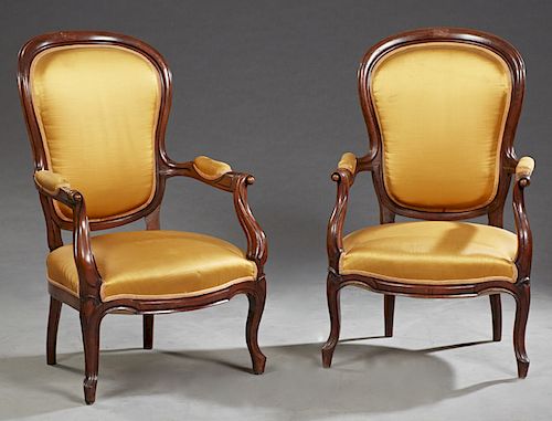 Pair of Louis Philippe Carved Mahogany Fauteuils, 19th c., the upholstered shield shaped backs over upholstered scrolled arms and a bowed seat, on cab