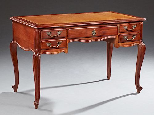 French Louis XV Style Carved Cherry and Beech Desk, 20th c., the stepped rounded edge and corner top with an inset gilt tooled salmon colored leather 