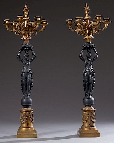 Pair of French Empire Style Gilt and Patinated Spelter Seven Light Candelabra, 20th c., the seven lights atop fruit baskets on the heads of classicall