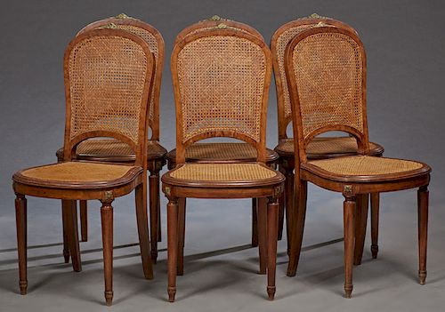 Set of Six French Louis XVI Style Ormolu Mounted Carved Walnut Caned Dining Chairs, 20th c., the arched caned backs over bowed cane seats, on turned t