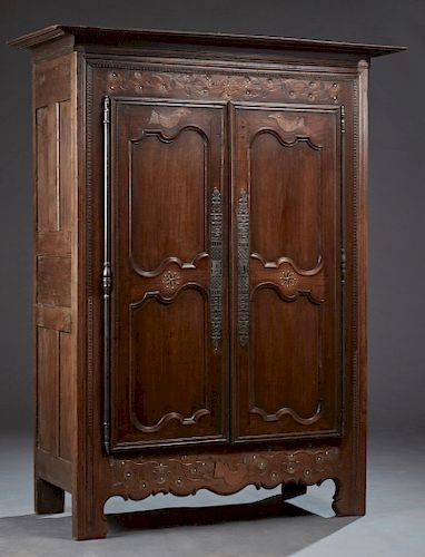 French Provincial Inlaid Carved Oak Armoire, early 19th c., Brittany, the stepped crown over double two panel doors with long steel escutcheons and ca