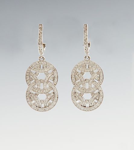 Pair of 14K White Gold Pendant Earrings, the diamond mounted half hoops suspending two intertwined diamond mounted circles, total diamond weight- 1.01