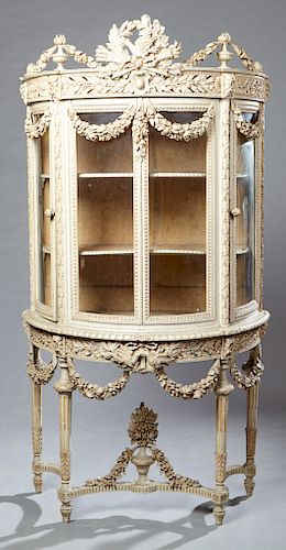 French Louis XVI Style Polychromed Curved Glass Vitrine, early 20th c., of demilune form, the pierced crossed torches and bird crest flanked by flamin