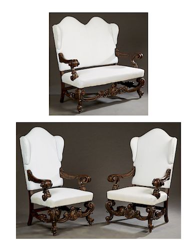 Italian Renaissance Style Carved Mahogany Parlor Suite, 20th c., consisting of a pair of fauteuils and a settee, all with arched upholstered backs ove