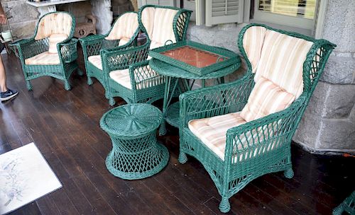 Eight pieces of antique Bar Harbor wicker to include two wing chairs, bookcase, one tall round top table, one low stool, two armchai...