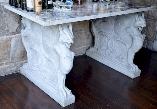 Marble table having mottled purple marble top set on base of double sided carved carrara marble winged griffins. 
height 35 inches, ...