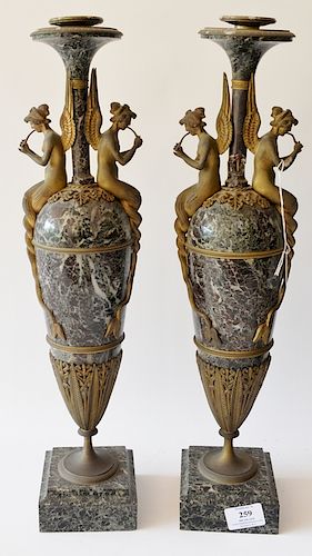 Pair of marble urns mounted with gilt bronze winged mermaids playing horns, set in bronze mounts on marble bases. 
height 19 1/2 inc...