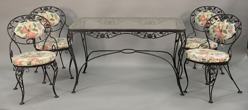 Five piece wrought iron glass top table and four chairs with custom cushions. ht. 29 in., top: 30" x 50"