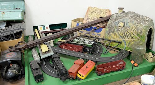 Lionel train and accessories including tunnels, bridge, lights, transformers, switches, and trucks plus HO track.