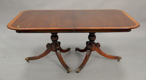 Mahogany double pedestal dining table with banded inlaid top and two 21 inch leaves. top: 44" x 68", opens to 110in.