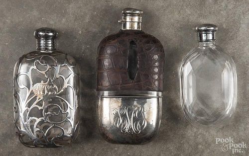 Three glass flasks, to include an example with sterling silver and an alligator skin cover