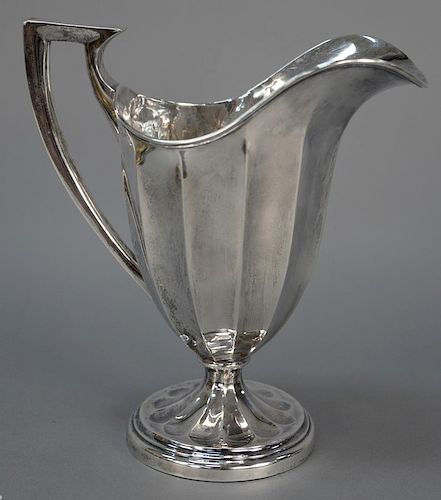 English silver pitcher having fluted body on round base. 
height 10 in., 
22.9 troy ounces