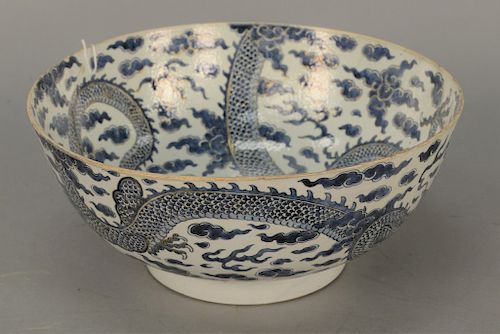 Large Chinese blue and white dragon punch bowl depicting painted gold outlined four claw dragon and flaming clouds inside and outsid...