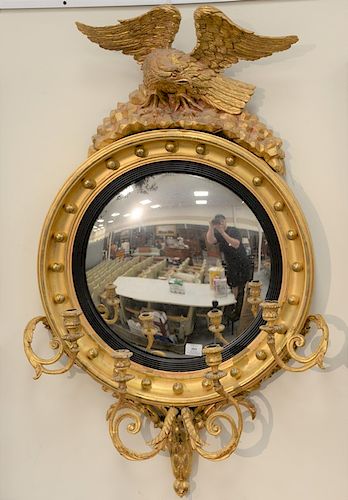 Girandole convex mirror mounted with carved eagle and four candle holders, 19th century.  height 45 in., diameter 25 1/2 in.