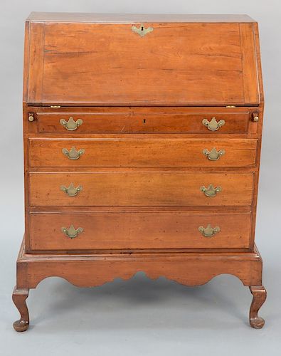 Cherry Queen Anne desk on frame, interior with center pull out compartment, drawers, and pidgeon holes, set on scalloped carved base...