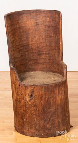 Carved trunk barrel chair.