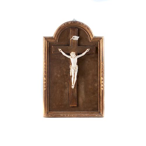 Cristo crucificado. Francia, finales del siglo XIX. Talla en marfil. Con marco de madera dorada y tericipelo color verde. Firmado.