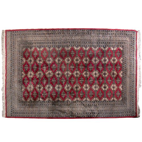 Alfombra. Origen iraní Siglo XX. Estilo Tekke. Elaborada a mano en fibras de lana y algodón. Decorada con motivos geométricos.