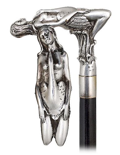 139. Silver Figural Cane -20st Century -Large L-shaped silver handle depicting the motif of Leda and the Swan, plain gilt collar, ebonized hard wood s