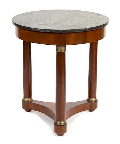 An Empire Style Gilt Metal Mounted Mahogany Gueridon Height 29 x diameter of top 26 inches.