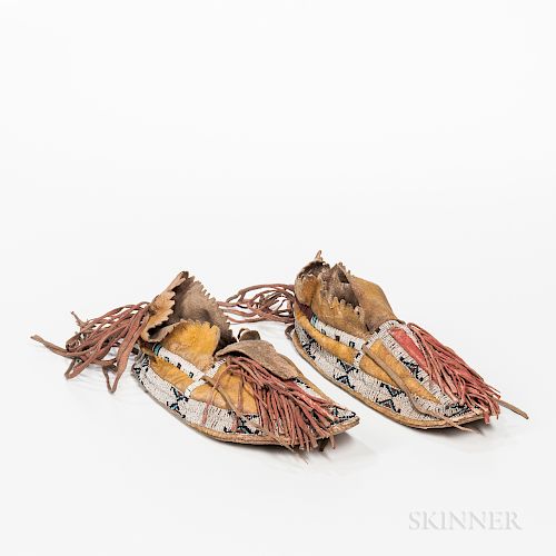 Southern Cheyenne Beaded Hide Man's Moccasins, c. 1880s, with long heel fringe, fringe off the vamp, painted with yellow pigments, and