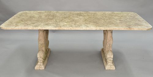 Outdoor table having marble top on base of two cement double dolphin base. ht. 28 in., top: 41" x 81"
