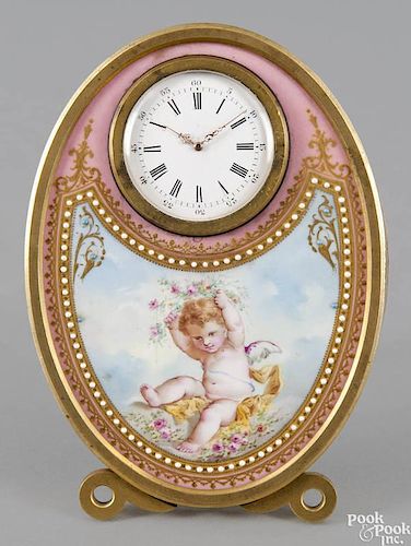 French bronze and porcelain oval desk clock, late 19th c., with hand-painted decoration of a cherub
