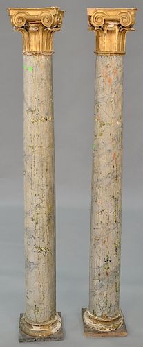 Pair of wood painted pilasters with gilt tops and faux marble bases, total height 82 inches.