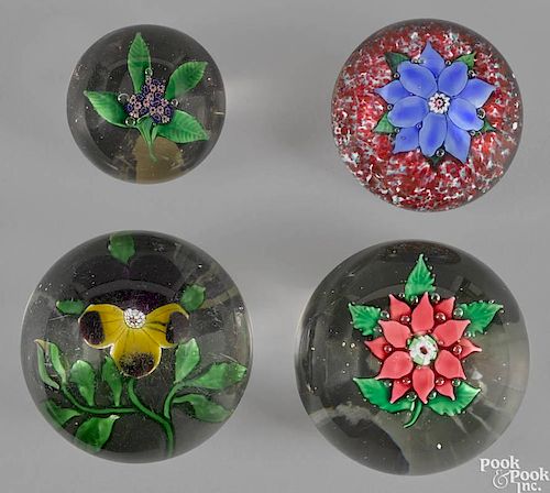 Four floral paperweights of varying sizes, to include an iris, anemones, and a millefiori