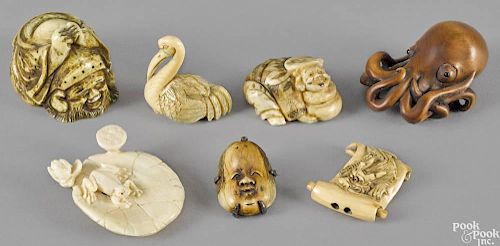 Seven Japanese netsuke, to include a boxwood octopus, an early ivory mask, a frog on a lily pad