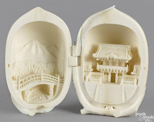Chinese carved ivory gourd, late 19th c., in two hinged sections, with relief landscape and shrine