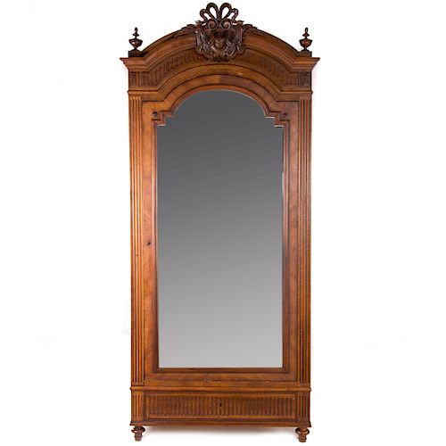 Armario. Siglo XX. Estilo Enrique II. En talla de madera de nogal. Puerta con espejo biselado, cajón, tirador de metal.