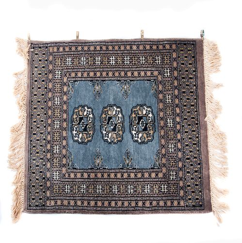 Alfombra. Pakistan, siglo XX. Estilo Bokhara. Elaborada en lana y algodón. Diseño cuadrangular. Con soporte de aluminio.