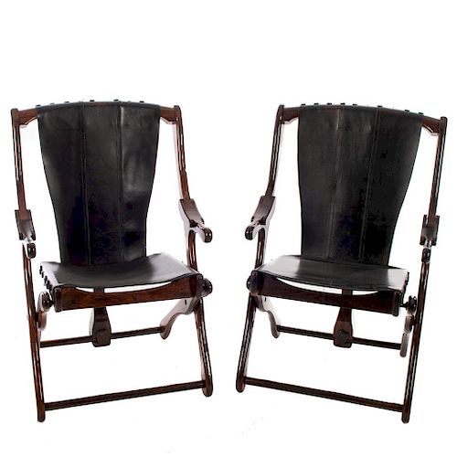 Par de sillas "Sling". México.  Años 70. Diseño Don S. Shoemaker. En talla de madera tropical. Con respaldo y asiento en piel negra.