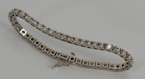 14 karat white gold tennis bracelet containing forty-four round diamonds, approximately 5 cts. 
total length 7 inches, 13.4 grams to...