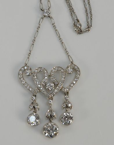 Platinum diamond link chain necklace, 
set with six round diamonds meeting one round diamond over pendant of three hearts, having on...