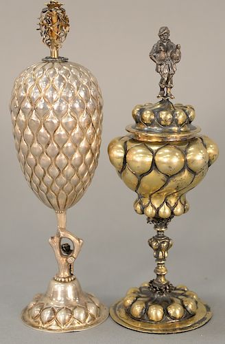 Two silver covered chalices, one marked sterling with floral finial and lobbed body, one having finial with man holding two geese an...