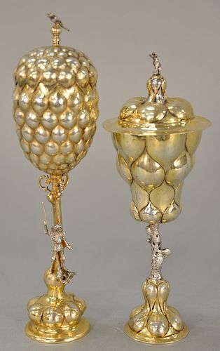 Two German silver chalices, 
one with figural stem and one with realistic tree stem, each with covers with finials. 
height 10 inche...