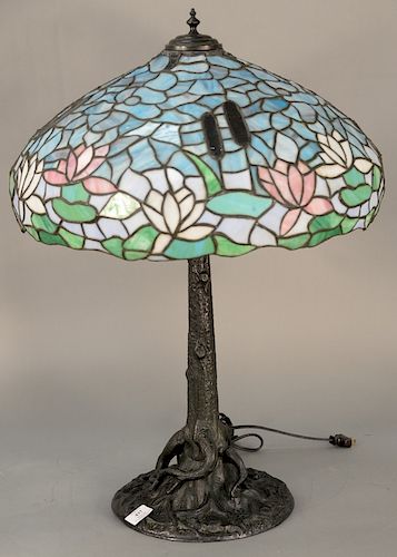 Table lamp having leaded glass shade with flowers and reproduction bronze base, shade is possibly Wilkinson. 