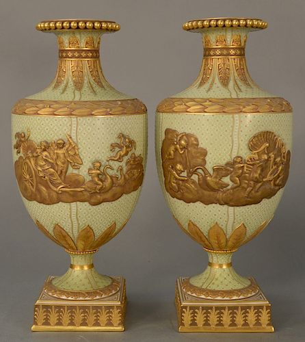 Pair of Wedgwood gilt decorated Victoria ware vases/urns, 
pale green with gold jeweled ground, central gilt relief chariot with put...