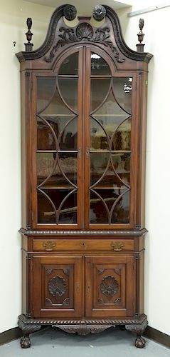 Pair of mahogany two part corner cabinets, 
carved broken arch tops over double arch top doors, on lower section with one drawer and...