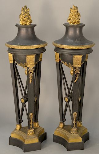 Pair of gilt and bronze torcheres having flame tops on supported stands with paw feet on gilt bronze base on bronze (in three parts)...