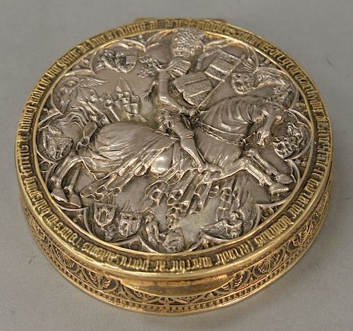 Silver round hinged covered box, 
cover embossed with center knight on horseback, gilt finish surround with writing, marked: .835. 
...